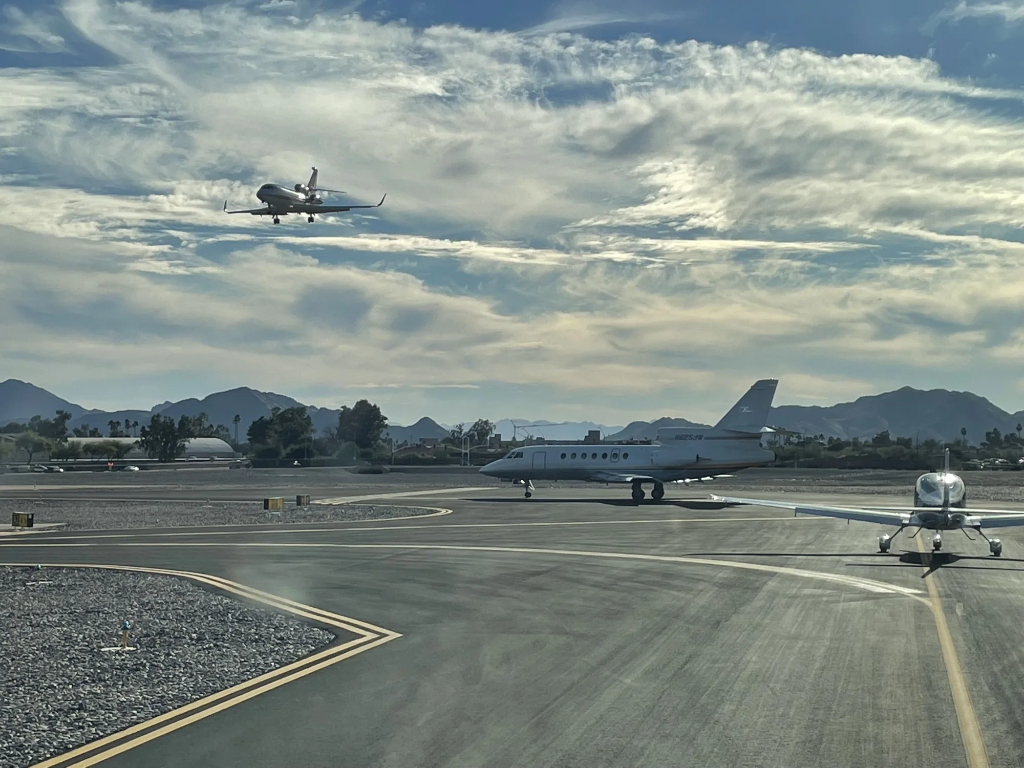 Business jets on the ramp with one on approach, supplemental private jet charter network